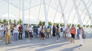 Μαρούσι : Με μεγάλη επιτυχία πραγματοποιήθηκε η περιήγηση «Ο δρόμος του Νερού» στο πλαίσιο των «Πολιτιστικών Διαδρομών» του Δήμου Αμαρουσίου Με μεγάλη επιτυχία πραγματοποιήθηκε η περιήγηση «Ο δρόμος του Νερού» στο πλαίσιο των «Πολιτιστικών Διαδρομών» του Δήμου Αμαρουσίου Με μεγάλη συμμετοχή δημοτών πραγματοποιήθηκε την Τετάρτη, 6 Ιουλίου 2022, η περιήγηση «Ο δρόμος του Νερού», στο πλαίσιο του Προγράμματος «Πολιτιστικές Διαδρομές» – πρωτοβουλία του Δημάρχου Αμαρουσίου Θεόδωρου Αμπατζόγλου. Το πρόγραμμα που διοργανώνει η Κοινωφελής Επιχείρηση του Δήμου Αμαρουσίου (ΚΕΔΑ), σε ορατά αρχαιολογικά μνημεία, που βρίσκονται εντός του πολεοδομικού ιστού της πόλης είναι δωρεάν και έχει ως στόχο τη γνωριμία των Μαρουσιωτών με τη φυσική και πολιτιστική κληρονομιά της πόλης, Η περιήγηση, με θέμα το Νερό, που διατρέχει τη μακραίωνη ιστορία της πόλης, αποτελώντας αιτία της αδιάκοπης κατοίκησής της από τους προϊστορικούς χρόνους έως τη σύγχρονη εποχή, υποστηρίχθηκε από την Εφορεία Αρχαιοτήτων Ανατολικής Αττικής, με παρουσίαση από την υπεύθυνη αρχαιολόγο της περιοχής του Αμαρουσίου, του Τμήματος Προϊστορικών και Κλασσικών Αρχαιοτήτων και Μουσείων, Θεοδώρα Τζεφέρη. Τα στελέχη της ΚΕΔΑ που υποδέχτηκαν τους συμμετέχοντες μετέφεραν τόσο τον χαιρετισμό του Δημάρχου Αμαρουσίου Θεόδωρου Αμπατζόγλου, όσο και του Προέδρου της ΚΕΔΑ Νίκου Πέππα, παρουσία και της συμβούλου του Δημάρχου επί θεμάτων πολιτισμού και υπεύθυνης για τις «Πολιτιστικές Διαδρομές», Άννας Βαγιωνά. Η διαδρομή ξεκίνησε από τον περιβάλλοντα χώρο του ΟΑΚΑ και συγκεκριμένα από τα φρεάτια 133,132 131 και 130 του Αδριάνειου Υδραγωγείου του 2ου αι. μ.Χ., του σπουδαιότερου τεχνικού έργου της αρχαιότητας στην Αττική και τη ρωμαϊκή δεξαμενή του 1ου-2ου αι. μ.Χ., που βρίσκεται ΒΑ του κεντρικού σταδίου. Δεύτερος σταθμός ήταν το αρχαιολογικό πάρκο επί των οδών Ζήνωνος Ελεάτου και Αγησιλάου (πλησίον του ΙΑΣΩ), ένας μεγάλης σημασίας αναδεδειγμένος αρχαιολογικός χώρος με αρχιτεκτονικά κατάλοιπα αγροικίας (villa rustica), που χρονολογούνται από τις αρχές του 3ου αι. μ.Χ. έως την Τουρκοκρατία και με ευρήματα που ανάγονται ήδη από τον 4ο αι. π.Χ. Η περιήγηση ολοκληρώθηκε στο κέντρο της πόλης, με το εκθετήριο αρχαίων υδραυλικών έργων (αγωγών) και σιρού, επί των οδών Βασιλίσσης Σοφίας και Παλαιολόγου (κτίριο Hondos Center) και τις δύο κεντρικές πλατείες, την Πλατεία Κασταλίας και την Πλατεία Ηρώων, που με τις ιστορικές κρήνες τους αποτελούν σημείο αναφοράς για την επί πολλούς αιώνες ταύτιση της πόλης με το νερό, στοιχείο συνδεδεμένο άρρηκτα με την οικονομία, την ιστορία, την παράδοση και την εξέλιξή της. Μετέφερε επίσης τις ευχαριστίες του Δημάρχου προς την Έφορο Αρχαιοτήτων Ανατολικής Αττικής και τα αρμόδια στελέχη της Υπηρεσίας για την υποστήριξή τους, με την επιστημονική γνώση και εμπειρία τους στο συγκεκριμένο Πρόγραμμα αλλά και σε άλλες δράσεις, καίριας σημασίας για τον Δήμο, όπως η διημερίδα «Διαχρονικό Μαρούσι. Αναζητώντας μια σύγχρονη φυσιογνωμία στη μνήμη της πόλης». Τέλος, ευχαριστίες οφείλονται προς τη Δημοτική Συγκοινωνία Αμαρουσίου, τον αρμόδιο Αντιδήμαρχο Γιάννη Ιωαννίδη και τους εργαζόμενους για τη μεταφορά των συμμετεχόντων προς και από τους χώρους περιήγησης. Σημειώνεται ότι, λόγω αυξημένου ενδιαφέροντος, η συγκεκριμένη πολιτιστική διαδρομή θα επαναληφθεί τον Σεπτέμβριο και θα είναι όπως όλες του Προγράμματος «Πολιτιστικές Διαδρομές» δωρεάν. Σχετική ανακοίνωση θα αναρτηθεί εγκαίρως στα διαδικτυκά μέσα ενημέρωσης του Δήμου Αμαρουσίου και στα τοπικά ΜΜΕ. Αμέσως επόμενες διαδρομές για το Φθινόπωρο: Περιήγηση στην Παραδοσιακή και τη Σύγχρονη Αρχιτεκτονική του Αμαρουσίου Περιήγηση στα Μουσεία και τις Τέχνες του Αμαρουσίου ΔΕΛΤΙΟ ΤΥΠΟΥ Μαρούσι, 12 Ιουλίου 2022